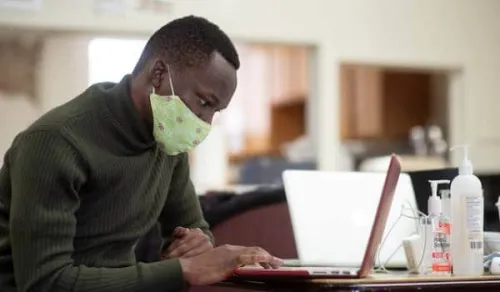 Man viewing a laptop at a table.