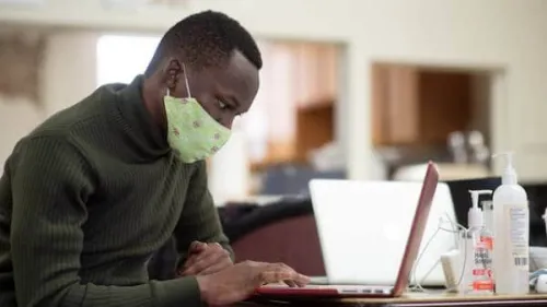 Man viewing a laptop at a table.