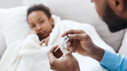 Photo of a father reading a thermometer to check if his daughter has a fever.