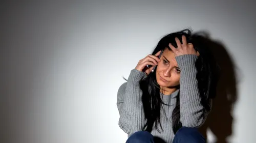 A woman on the phone, appearing to be stressed or worried