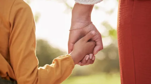 An adult and a child holding hands