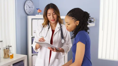​​Una doctora y una paciente están revisando juntas la información del paciente​