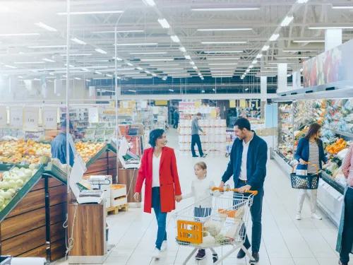 Photo of people shopping for food in a supermarket.