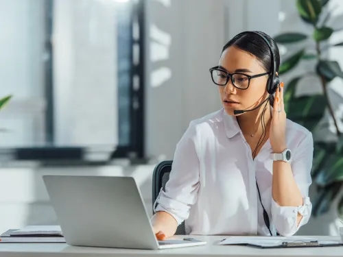 Photo of a woman translator with headset and laptop computer.