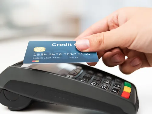 Photo of a person using their credit card on a credit card reader