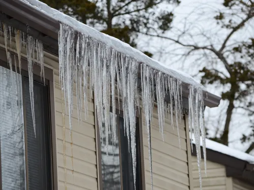 Icicles form from the roof of an apartment during freezing conditions