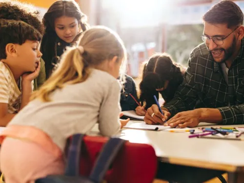Students engaging in an after-school program with an adult leading the activity