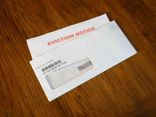 A photo of an open envelope on a table that contains an eviction notice.