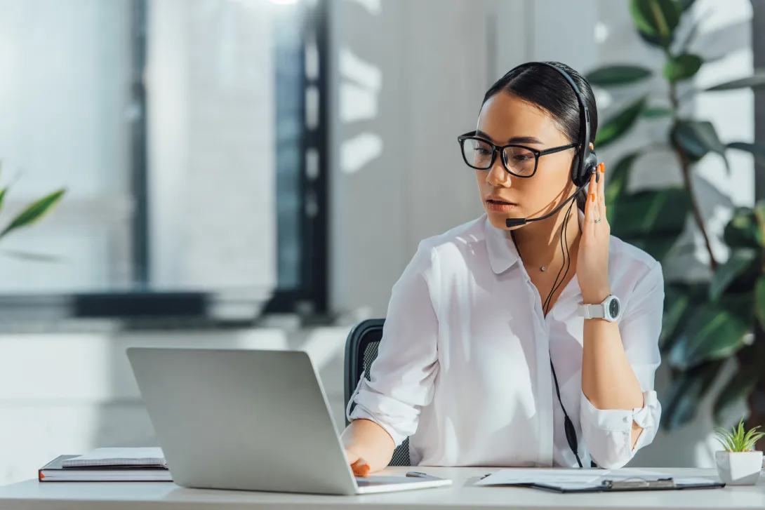 Photo of a woman translator with headset and laptop computer.