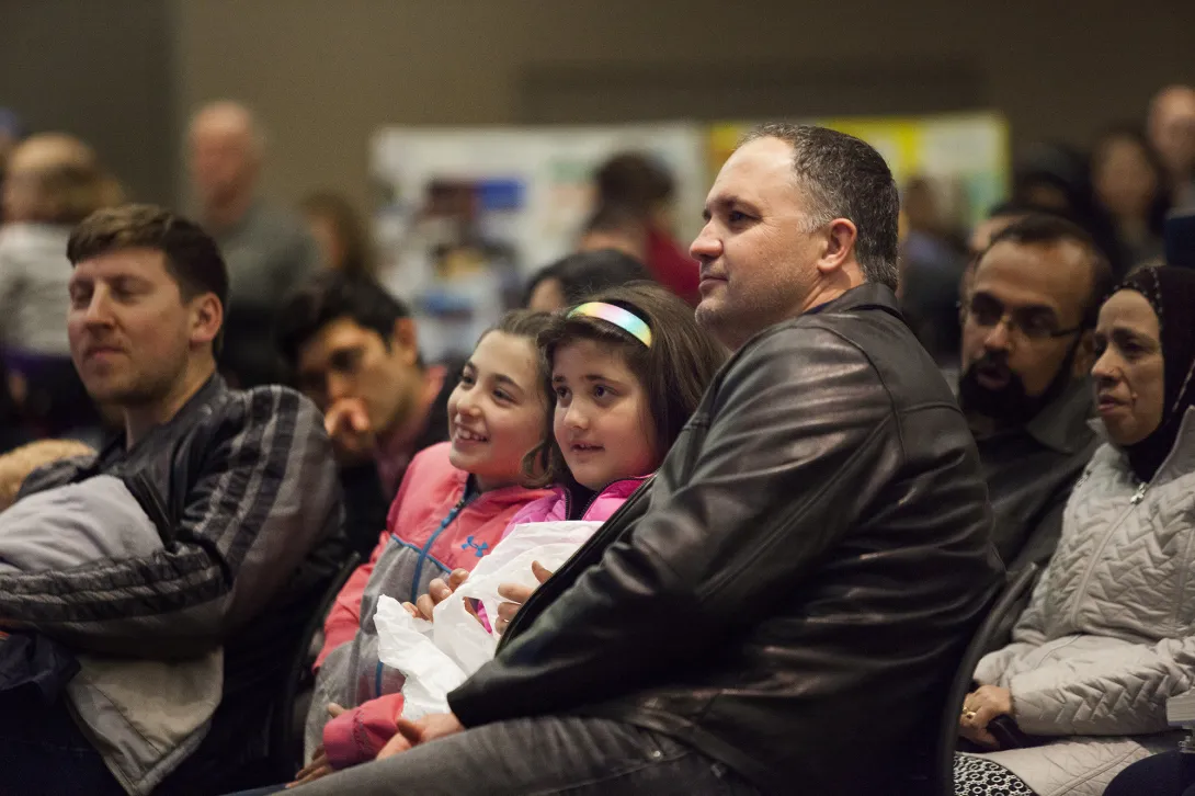 Photo of adults and children at an educational community event.