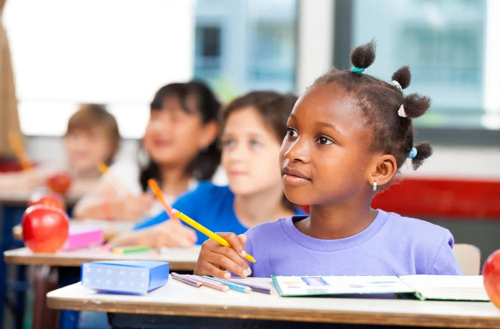 Child sitting at desk learning with classmates