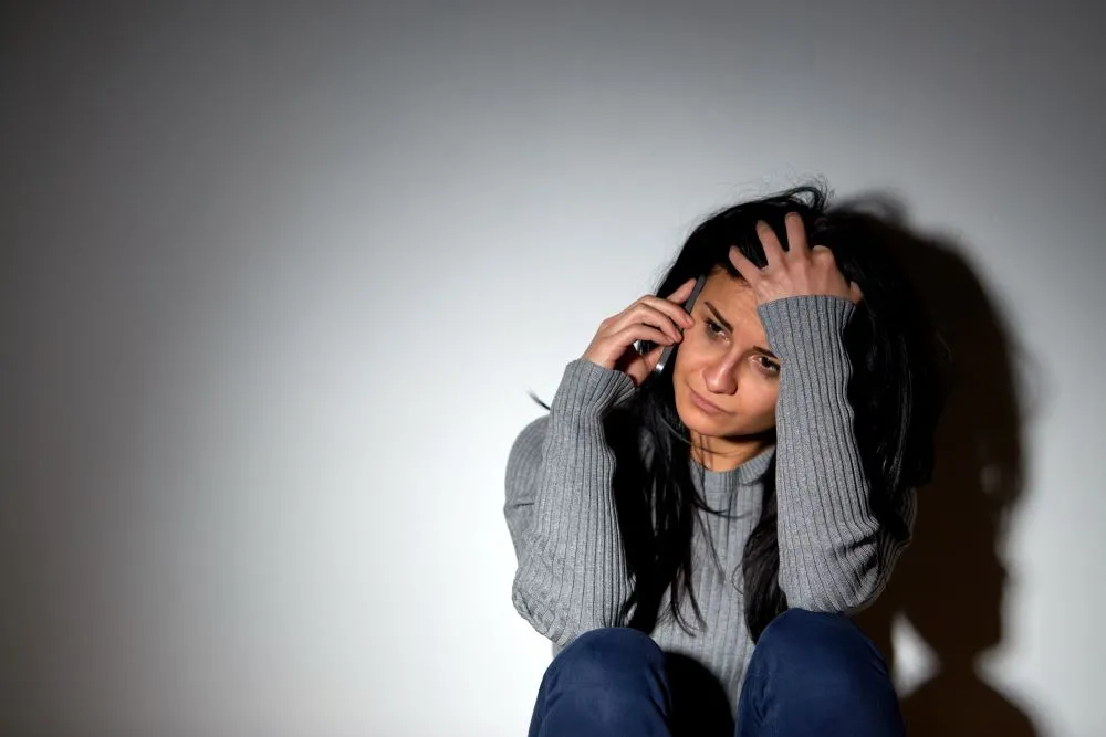 A woman on the phone, appearing to be stressed or worried