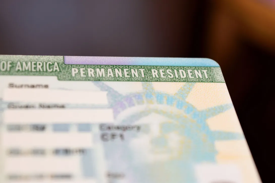 Una tarjeta de residencia permanente con los nombres difuminados para mantener la confidencialidad.