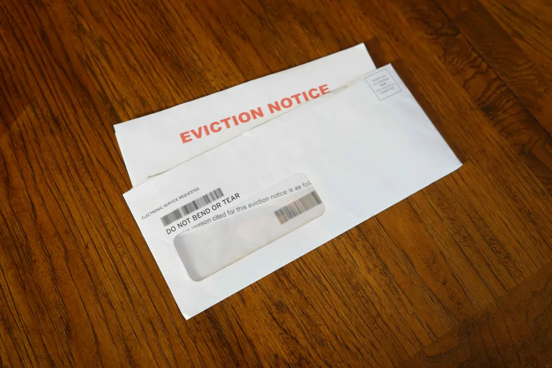 A photo of an open envelope on a table that contains an eviction notice.